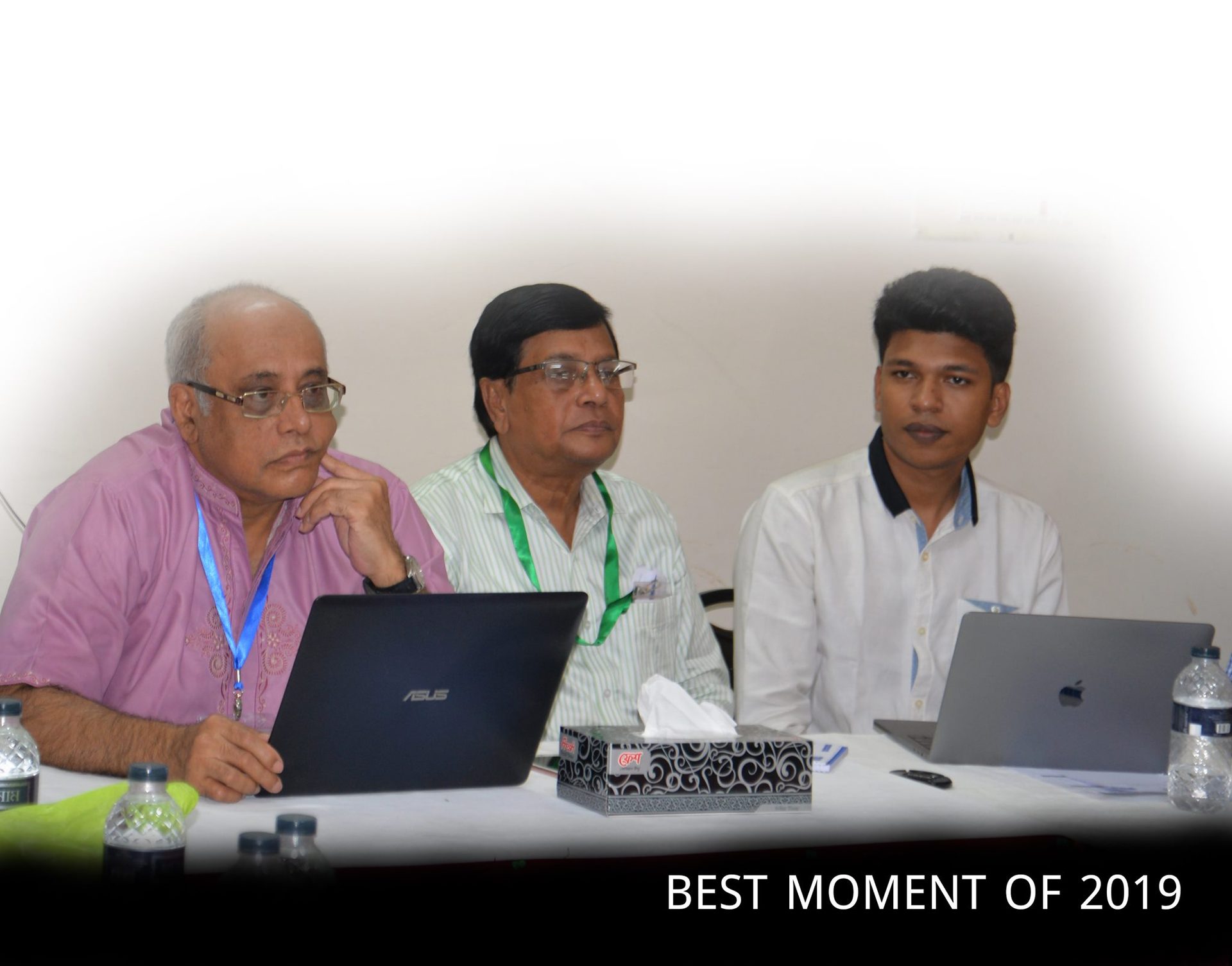 Raihan Khan with two colleagues reviewing laptops during a memorable 2019 MTI Ltd. meeting.