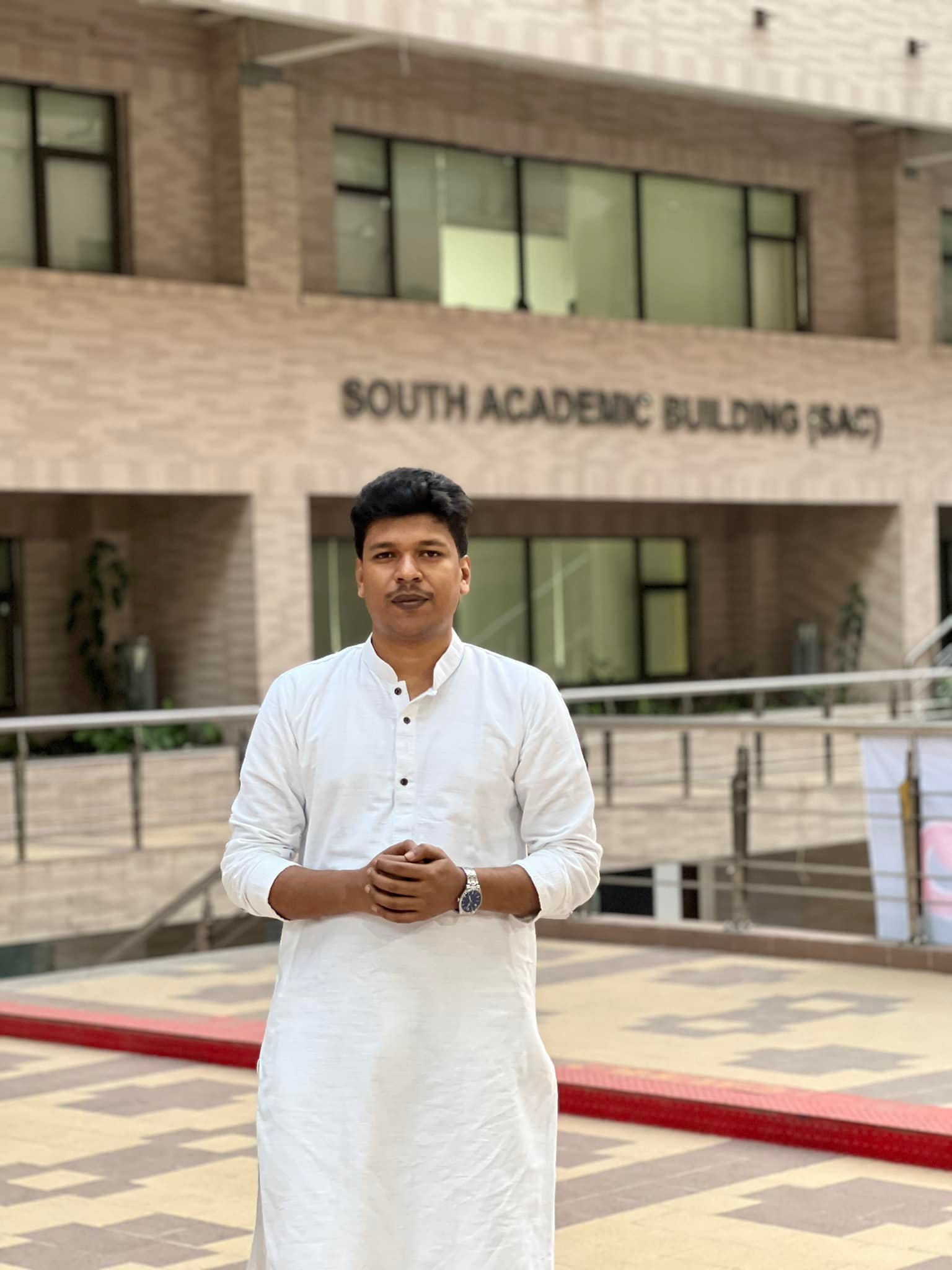 Raihan Khan standing in front of the South Academic Building (SAC) at North South University.