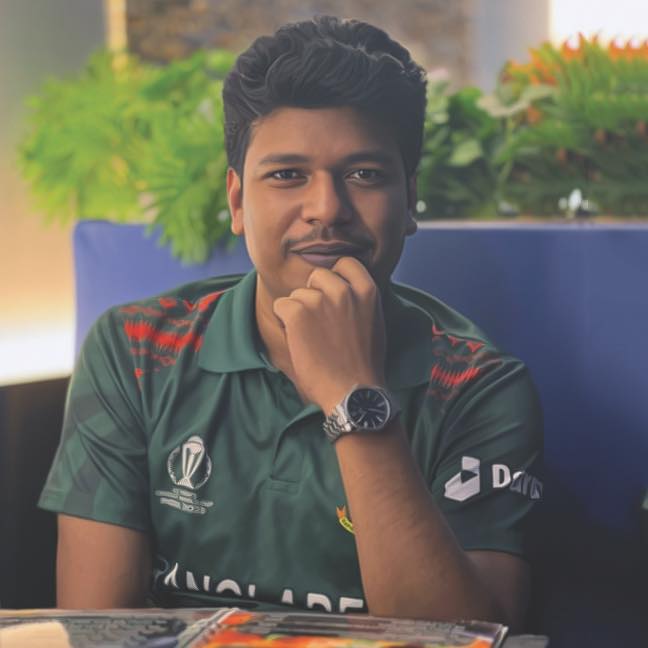 Raihan Khan wearing a Bangladesh cricket jersey resting his chin on his hand in a thoughtful pose.
