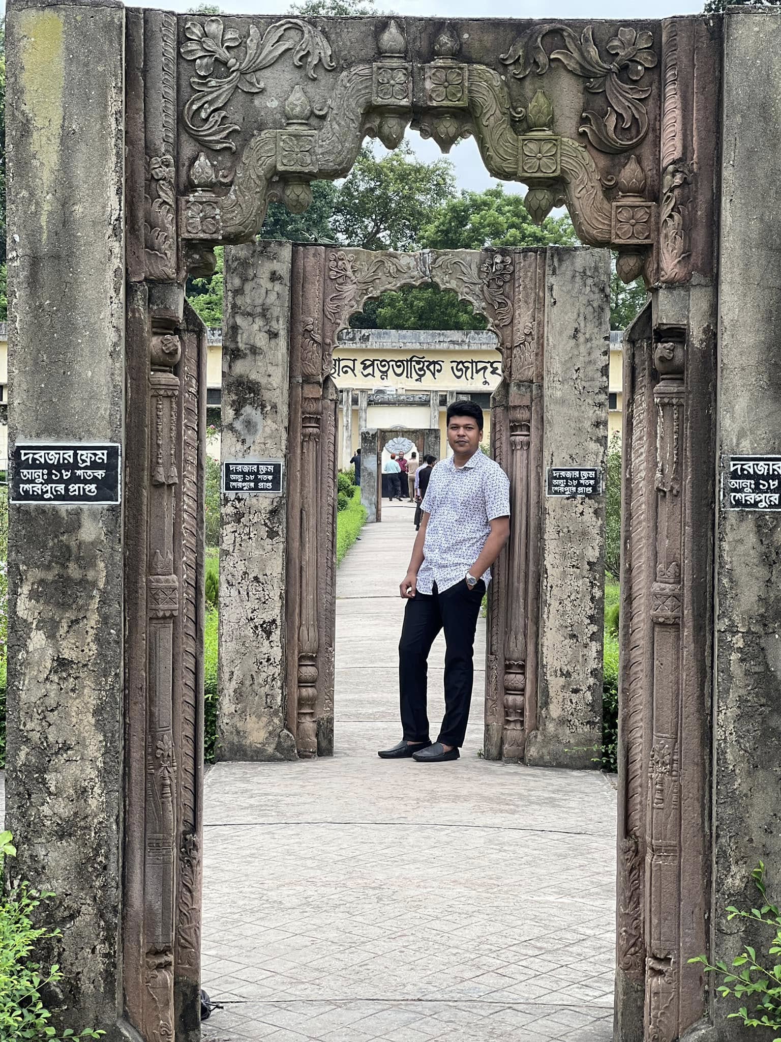 Raihan Khan standing inside a carved stone archway at an archaeological museum in Bangladesh.