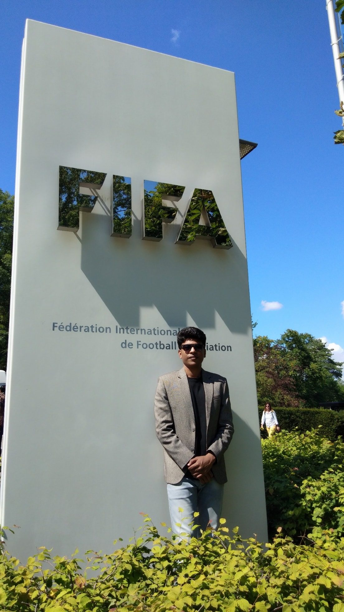 Raihan Khan standing beside the FIFA headquarters sign in Zurich, Switzerland.
