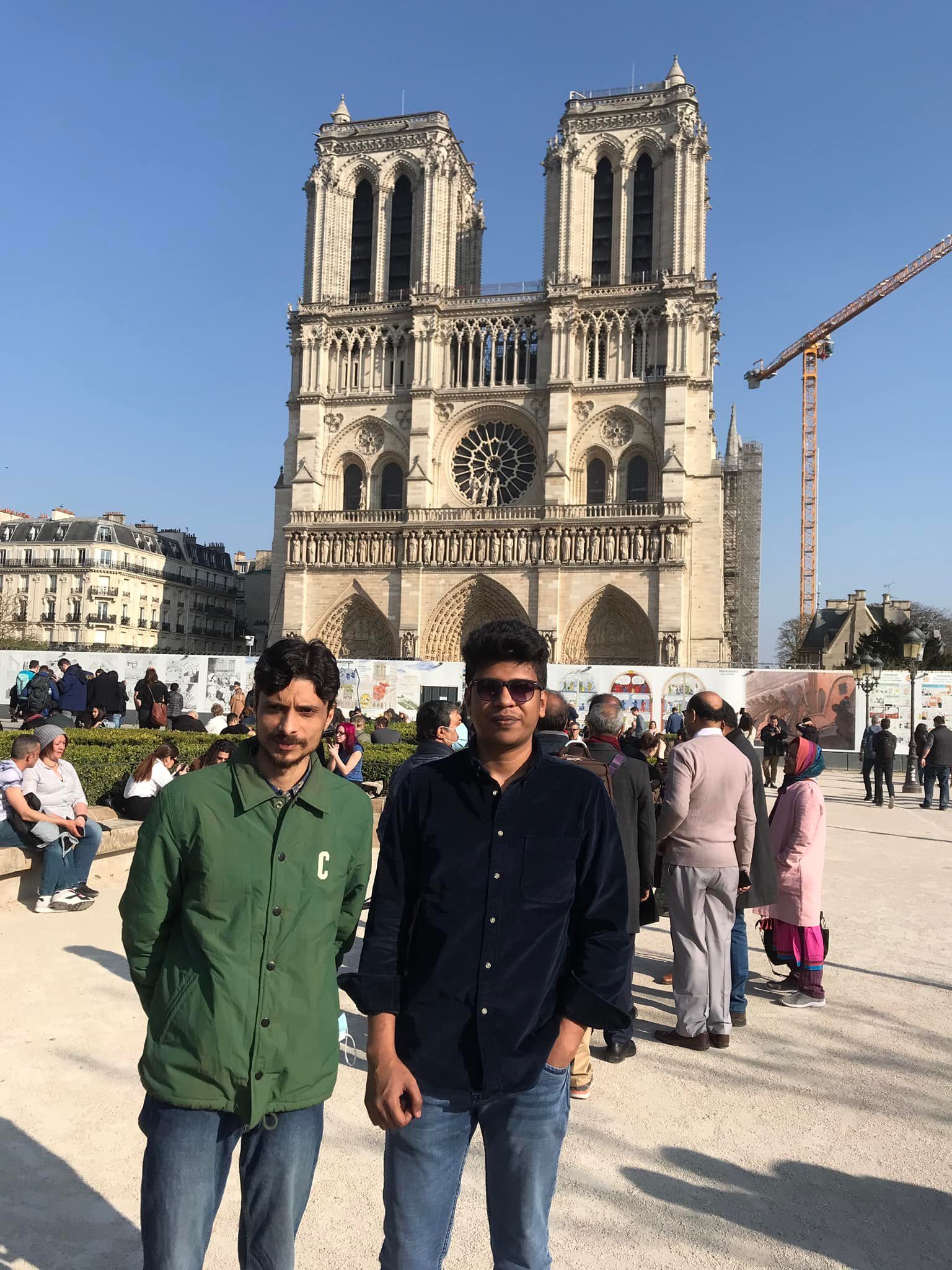 Raihan Khan and a friend standing together in front of Notre-Dame Cathedral in Paris.